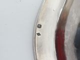a close up of a silver spoon on a white table