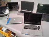 several laptops are lined up on a table in a room