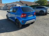 the rear end of a blue car parked in a parking lot