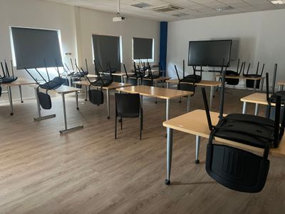 a room that has a bunch of desks and chairs in it
