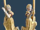 pair of antique figurines of a girl and a boy with a candle