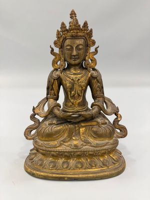 une statue en laiton représentant un Bouddha assis en position du lotus