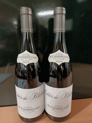 deux bouteilles de vin posées sur une table l'une à côté de l'autre