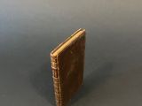 a small brown book sitting on top of a gray table