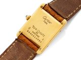 a close up of a watch on a white surface with a brown strap