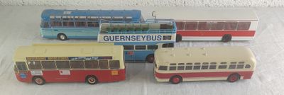 quatre petits bus en plastique posés sur une table