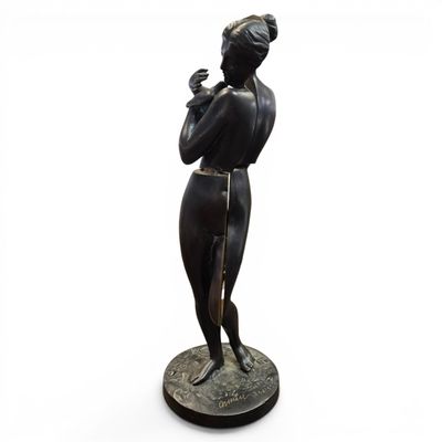 bronze statue of a woman holding a bird on a pedestal