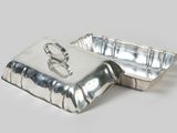 pair of silverplated dishes with lids and handles on a white surface