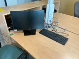 a desk with a computer monitor and keyboard on it