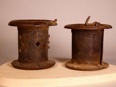 two old spools sitting on top of a wooden stand