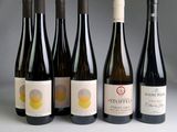 six bouteilles de vin sont alignées sur une table