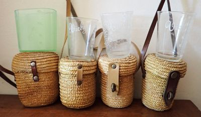 trois tasses en osier et un porte-verre posés sur une table en bois