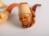 a statue of a man with a hat and a pipe next to it