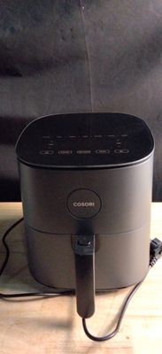 une enceinte noire posée sur une table en bois