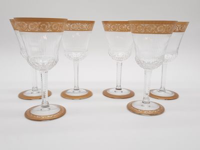 quatre verres à vin à bord doré sur fond blanc