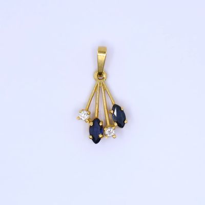 a close up of a gold pendant with blue and white stones