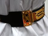a black belt with gold studs on it and a white shirt