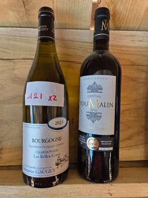 trois bouteilles de vin sont alignées sur une étagère à côté d'une bouteille de vin