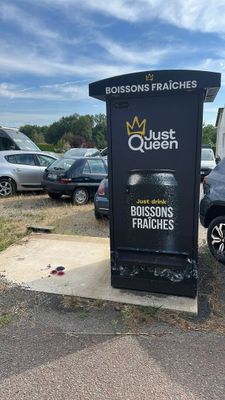 cars parked in a parking lot next to a black trash can
