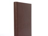 an old book with a brown cover sitting on top of a white surface