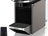 un gros plan d'une machine à café avec une tasse de café à côté