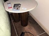une petite table sur laquelle se trouve un magazine, à côté d'une chaise