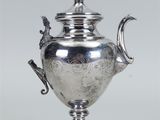 une théière ancienne en argent ornée d'un oiseau sur le couvercle