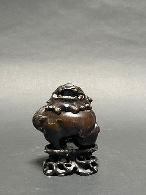 a figurine of a frog sitting on a tree stump