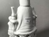 a white figurine of a person holding a pipe