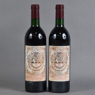 two bottles of red wine sitting next to each other on a table