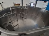 une photo d'un grand saladier en acier inoxydable dans une usine