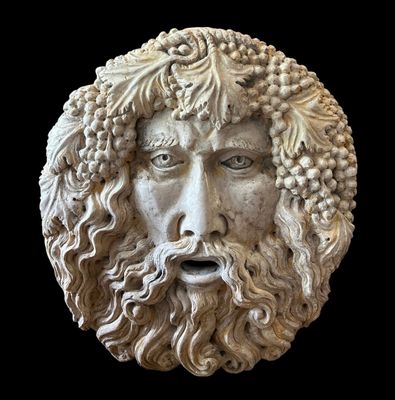 statue d'un homme barbu, avec une barbe de raisins sur la tête