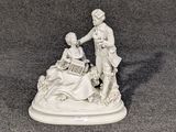une figurine représentant un homme et une femme jouant d'un instrument de musique