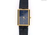 une photo d'une montre-bracelet plaquée or montée sur un bracelet en cuir noir