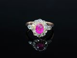 un gros plan d'une bague sertie d'un diamant rose et blanc sur une surface noire