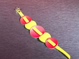 a yellow and red watch on a black surface