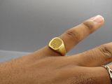 a person ' s hand with a gold ring on it