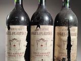 trois bouteilles de vin rouge posées côte à côte sur une table