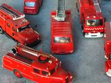 beaucoup de camions de pompiers miniatures posés sur la table