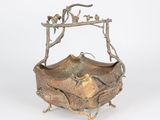 an old bronze bowl with a bird on top of it