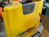 a yellow container sitting on the floor next to a construction cone
