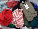 a pile of clothes that is sitting on a bed
