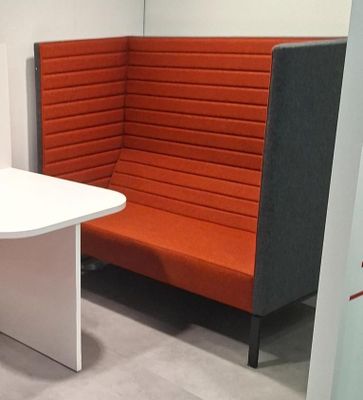 une banquette d'angle avec une table et une chaise dans le coin