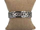 bracelet en argent avec un motif noir et blanc sur un coussin