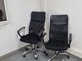deux chaises de bureau noires placées l'une à côté de l'autre dans une pièce
