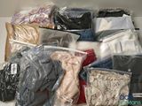 many different types of clothes in bags on a shelf