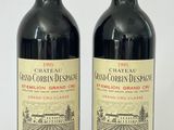 deux bouteilles de vin rouge posées l'une à côté de l'autre sur une surface blanche