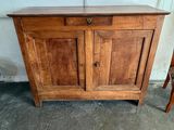 un petit meuble en bois muni d'une porte et d'une chaise
