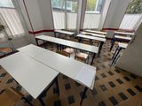 many tables and chairs in this empty classroom
