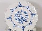 four blue and white plates stacked on top of each other